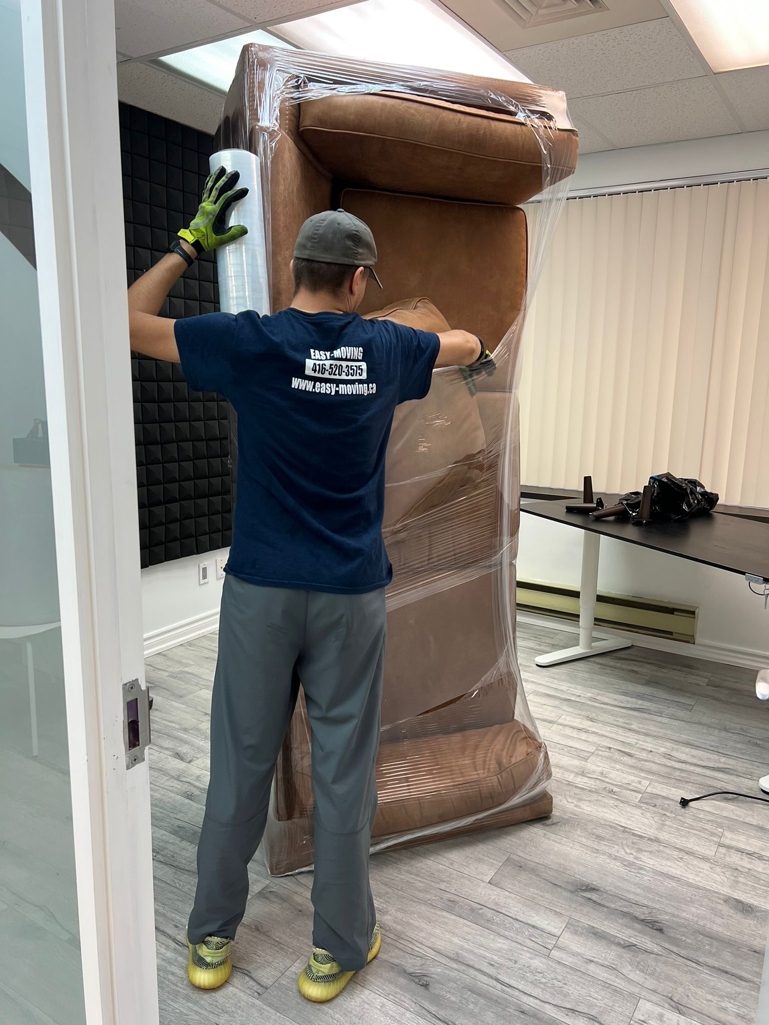 Easy Moving crew wrapping a sofa before transport